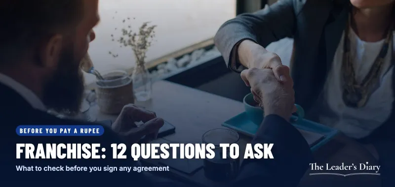Representative image: two people shaking hands over a business agreement at a coffee shop table